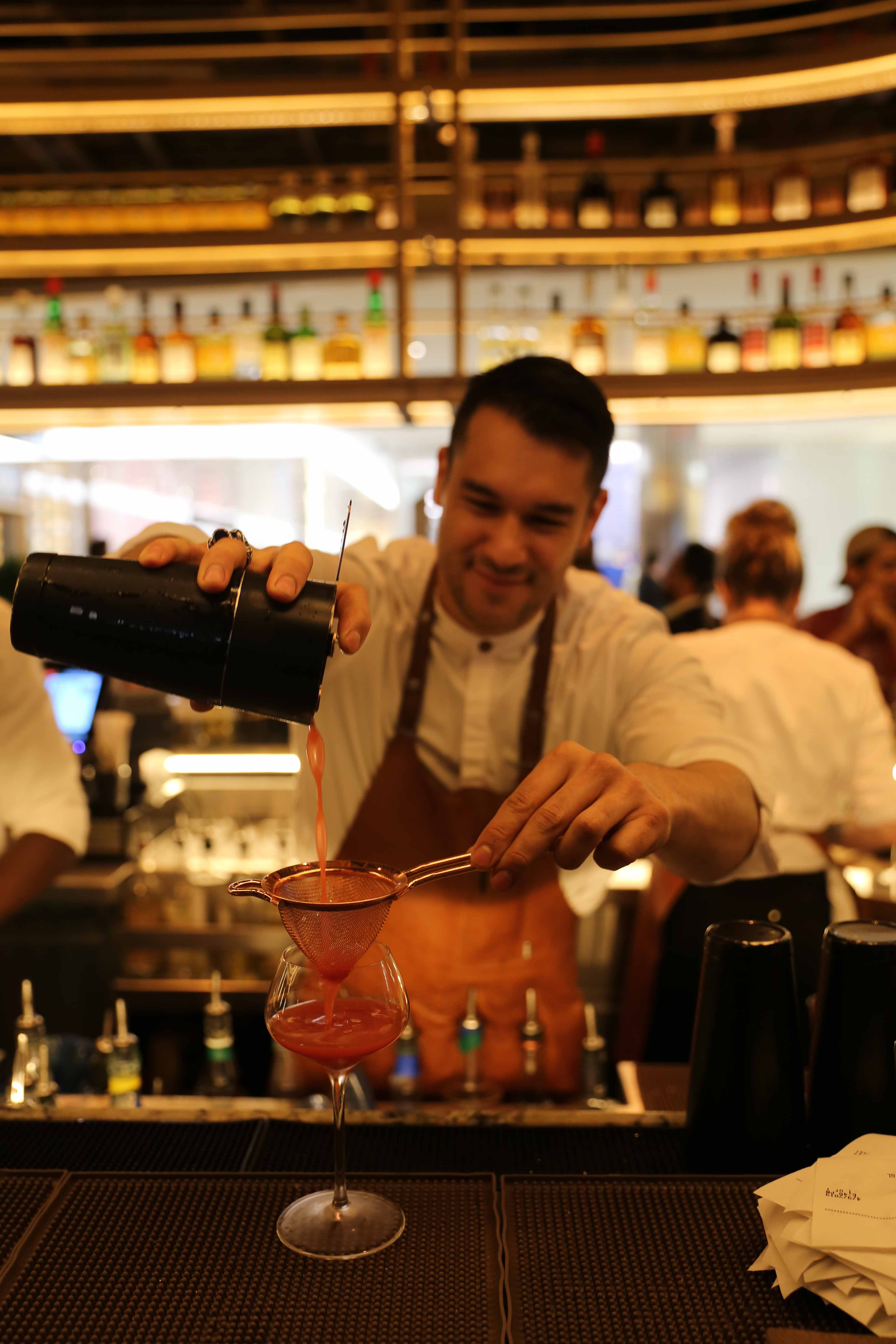 Wild Ink bartender pouring cocktail